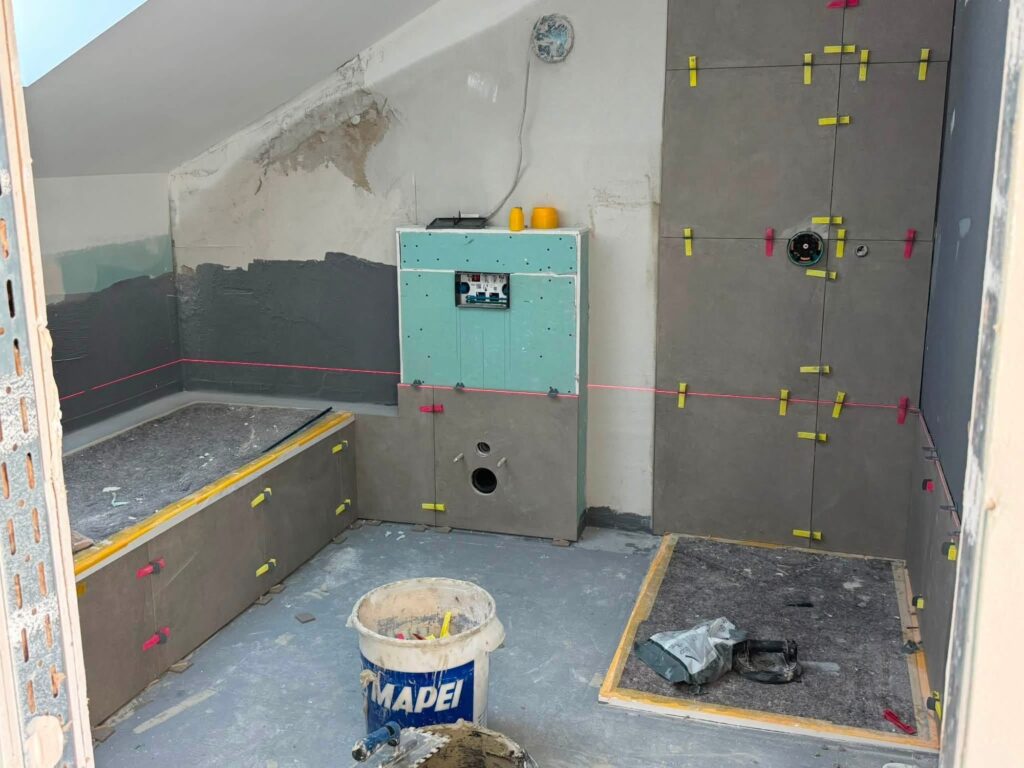 Badezimmer mit Dachschräge während der Wandfliesen-Verlegung – AG-die Handwerker