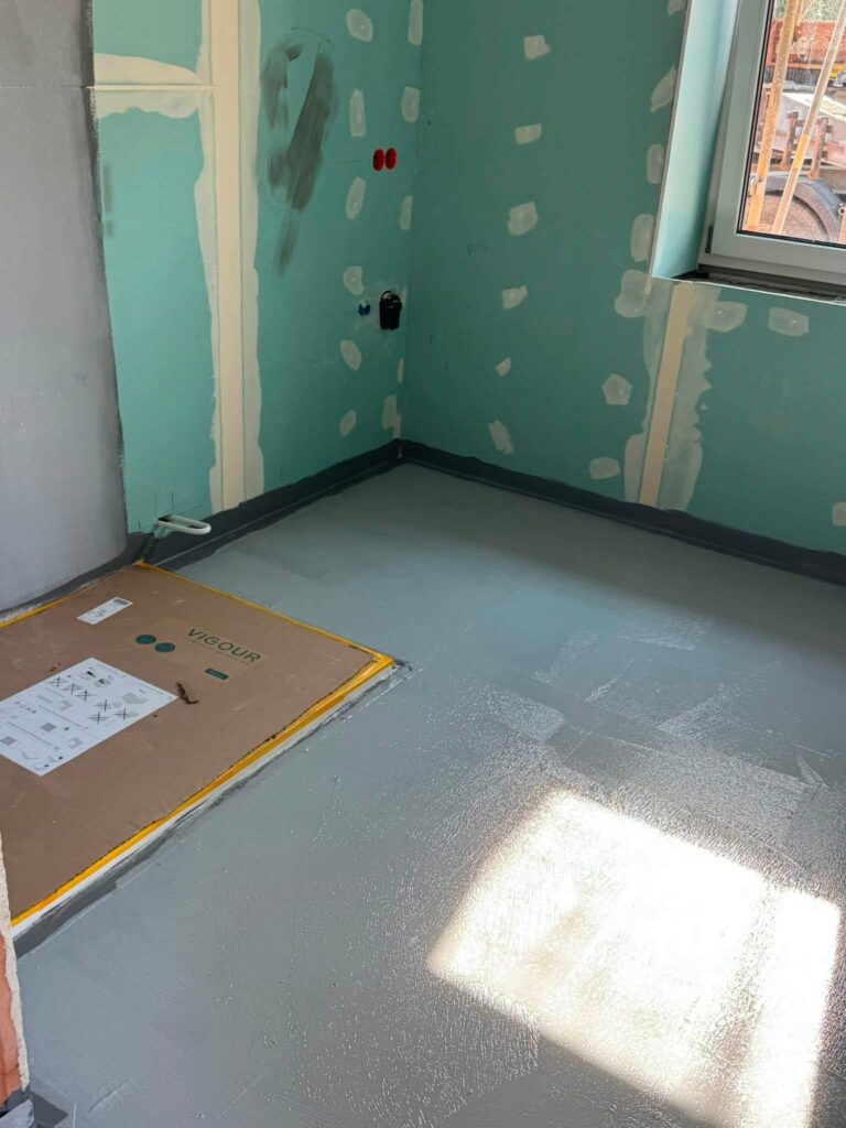 Badezimmer mit vorbereiteten Wänden und abgedichtetem Boden vor dem Fliesen