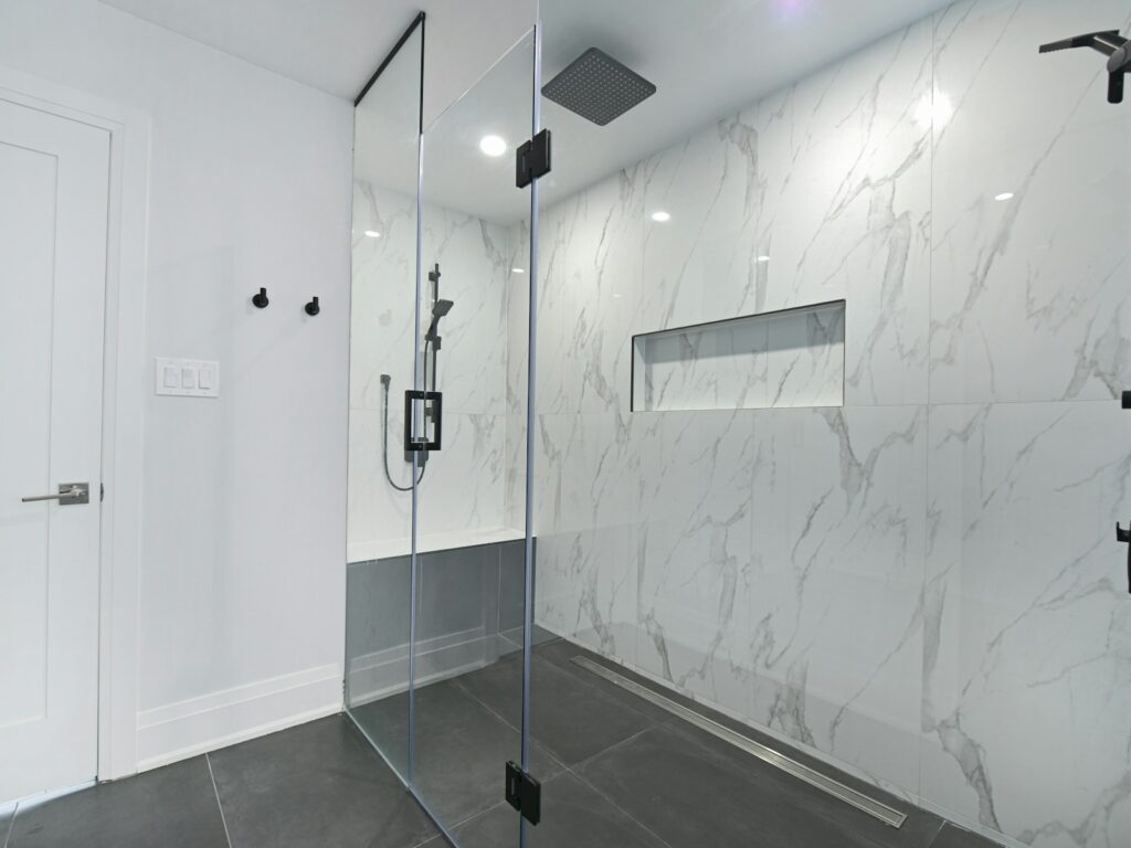 Modernes Badezimmer mit bodengleicher Dusche und großformatigen Fliesen